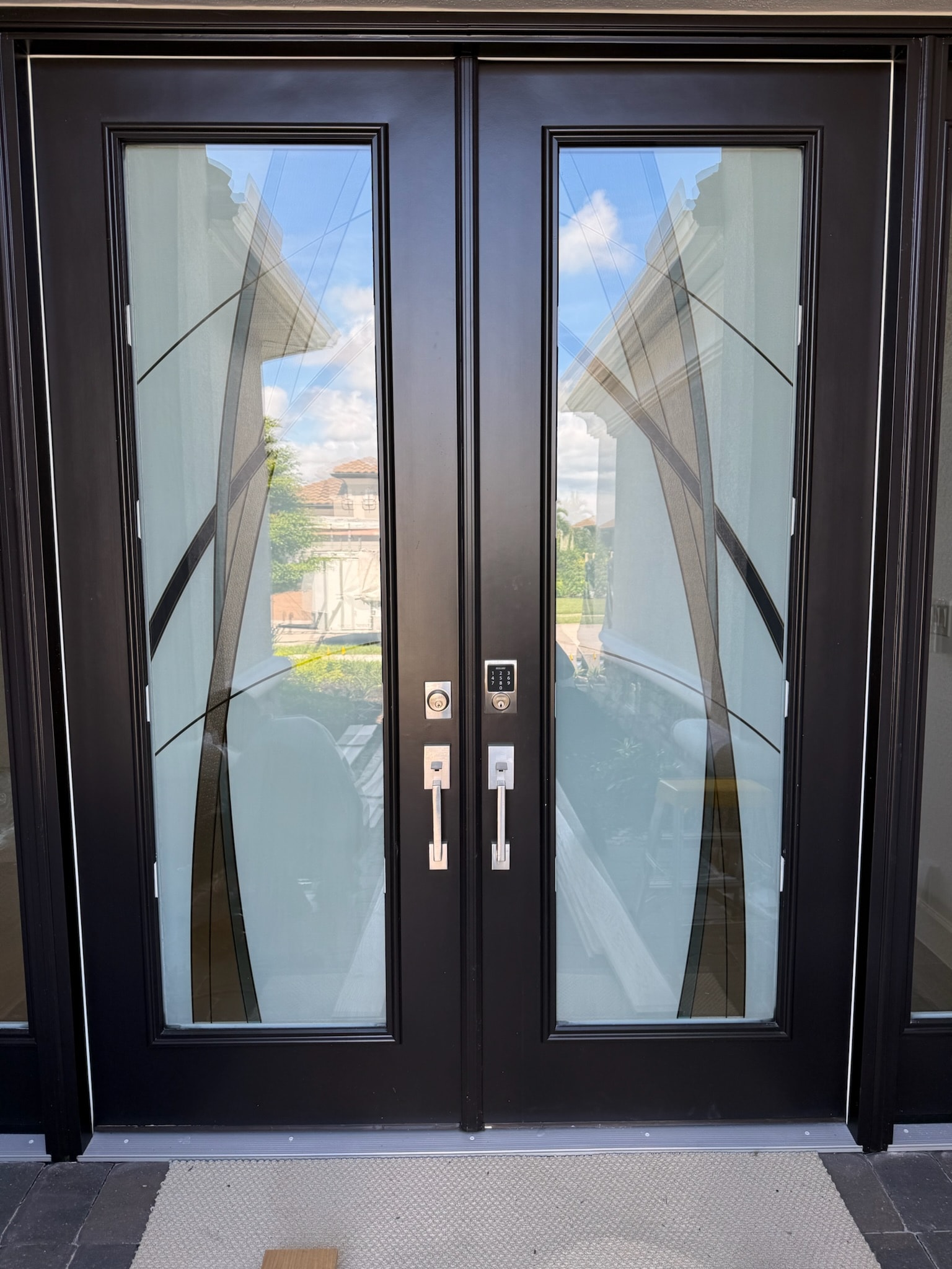 Custom decorative film applied to black double glass entry doors